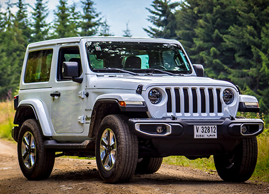 White 2 door Jeep Wrangler parked in the outdoors.