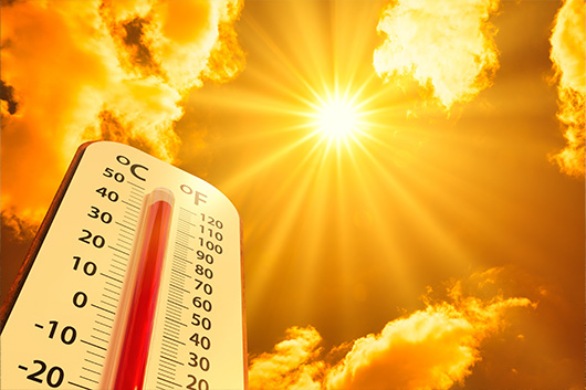Image of a thermometer sitting under the sun, indicating warm weather.