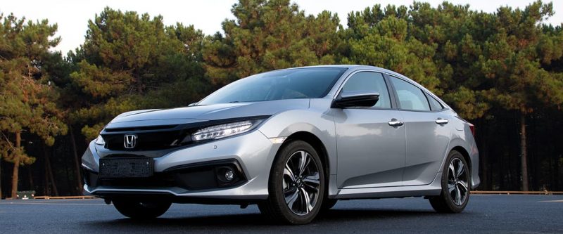 Image of a Honda Civic, parked outside with trees in the background.