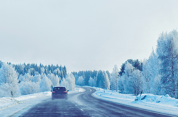 Image of someone driving in the winter season.
