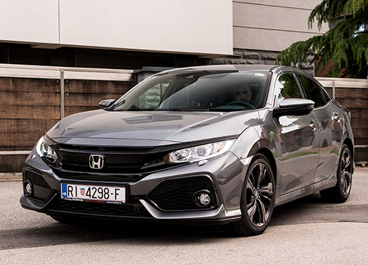 Gray Metalic Honda Civic parked outside.