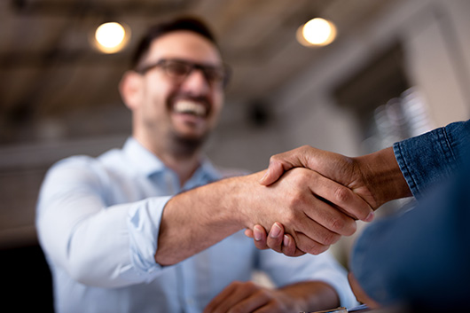 Image of a gentleman, shaking hands with a sales person after negotiating a deal.
