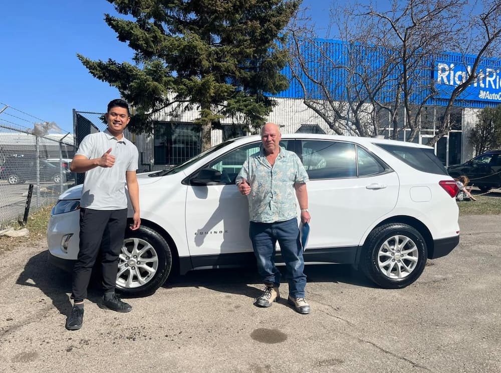 Image of RightRide employee, standing beside a happy customer.