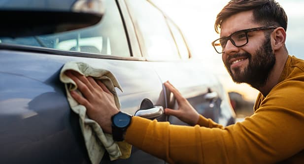 Car owner cleaning his vehicle, making sure it's ready to be traded in.