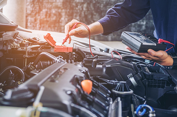 Mechanic checking the car battery of a car.