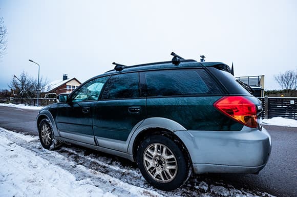 Image of a used SUV, parked on the side of a road during the winter season.