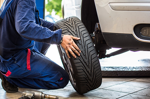 Image of a mechanic, changing a car tire.