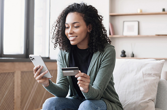 Portrait of a woman smiling, looking at her credit score after getting help from RightRide's insolvency team.