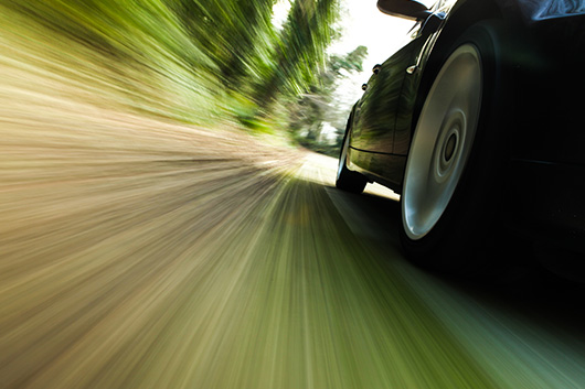 Image of a side angle shot of a vehicle speeding with a motion blur background