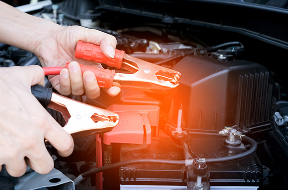 Image of a mechanic jump starting a battery.
