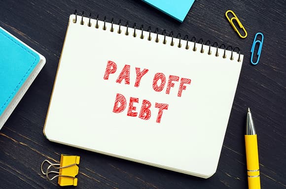 Image of a notebook that says "Pay off debt".