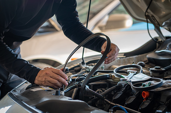 Mechanic changing out the timing belt of a vehicle.