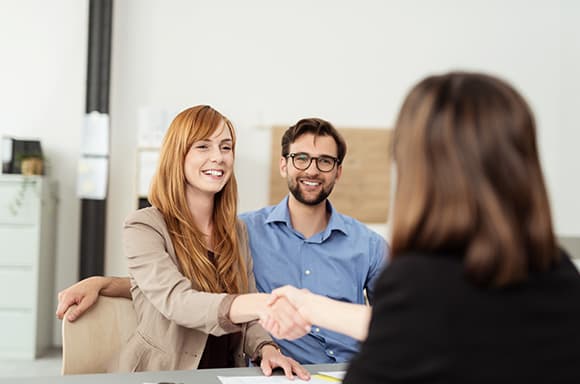 Image of a couple, speaking to a financial expert, getting advice to fix their finance problems.