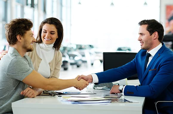 Image of a customer, shaking hands with a car sales person